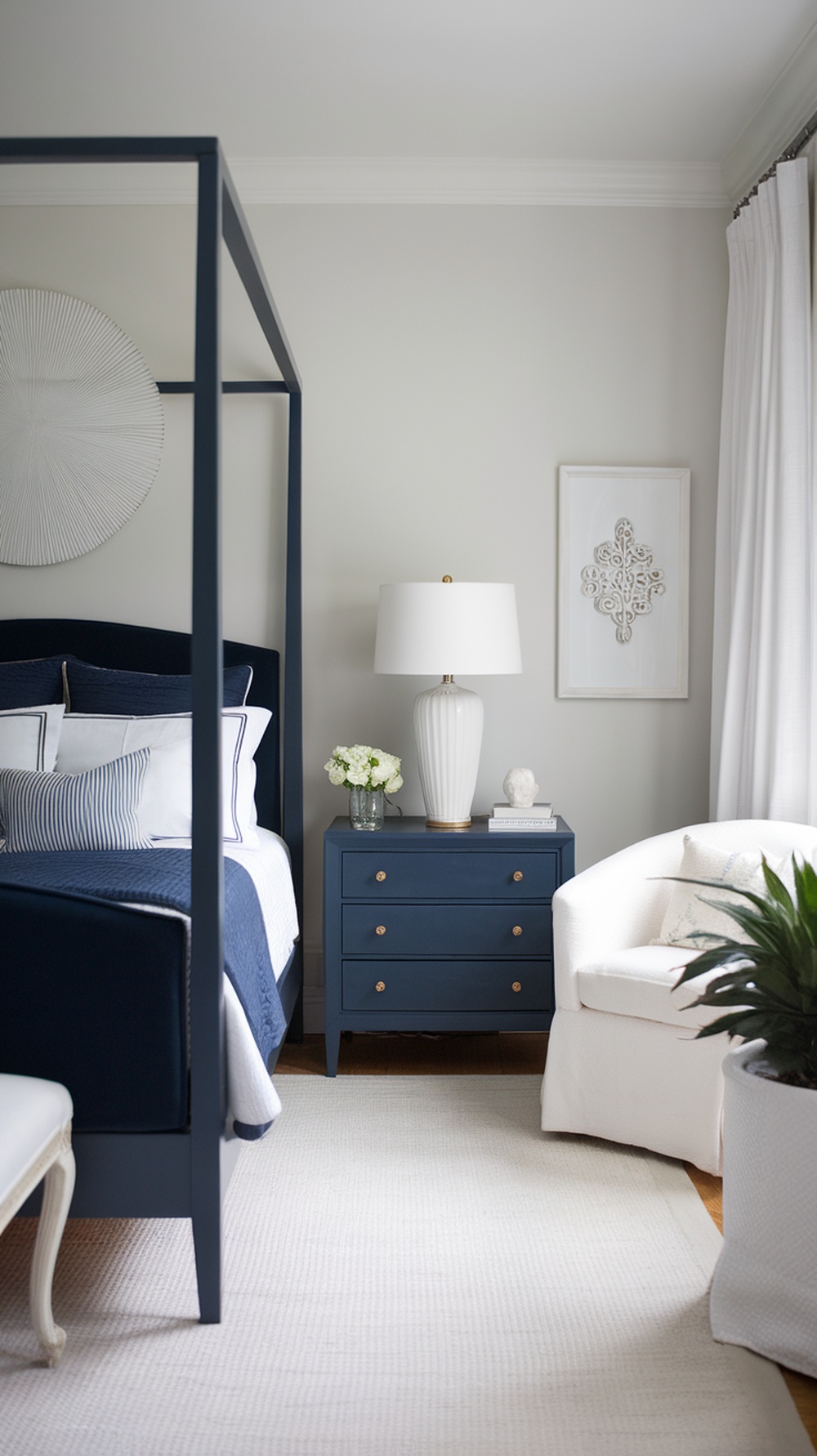 A navy blue bedroom featuring a four-poster bed, matching nightstand, and a cozy white armchair.