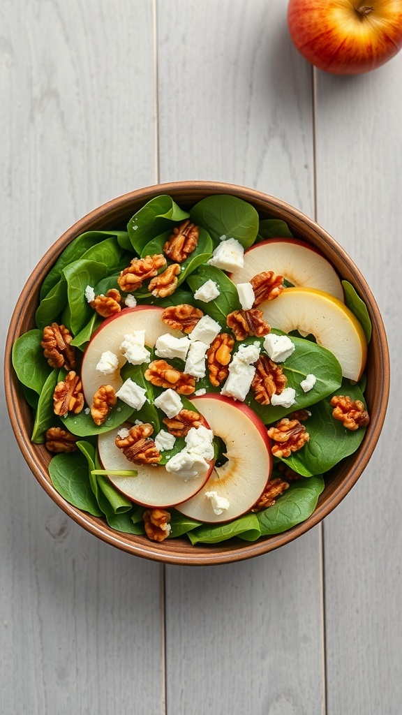 A bowl of Apple and Walnut Spinach Salad topped with sliced apples, walnuts, and feta cheese.