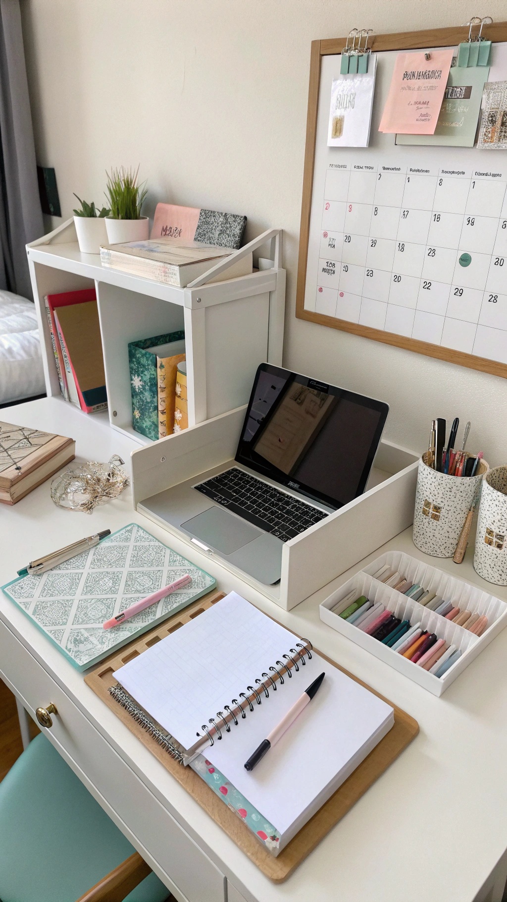 A stylishly organized desk with a laptop, notebooks, and colorful stationery.