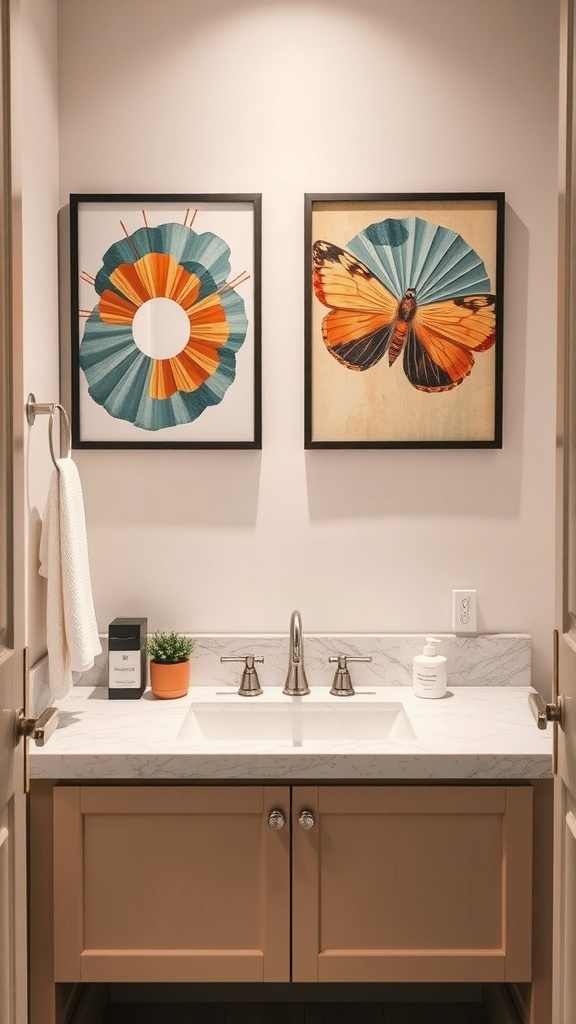 Two framed art pieces above a bathroom counter featuring colorful designs and a butterfly.