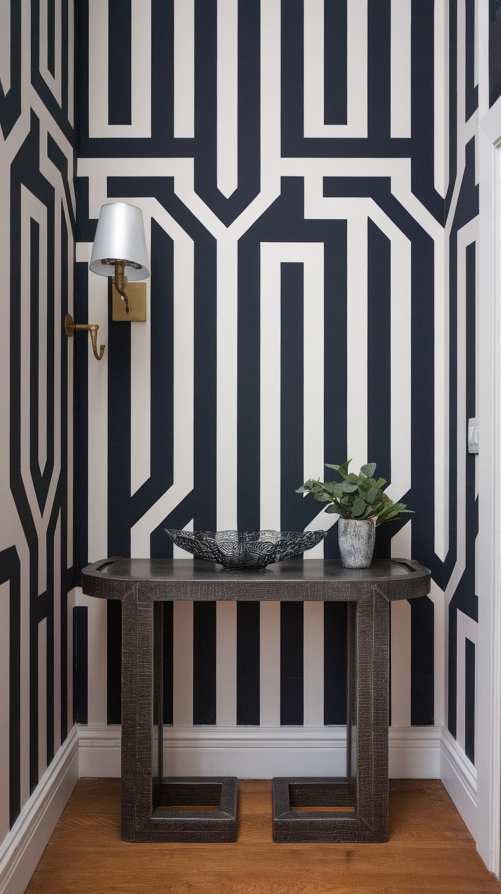 Entryway featuring bold geometric wallpaper in black and white with a console table and decorative items.