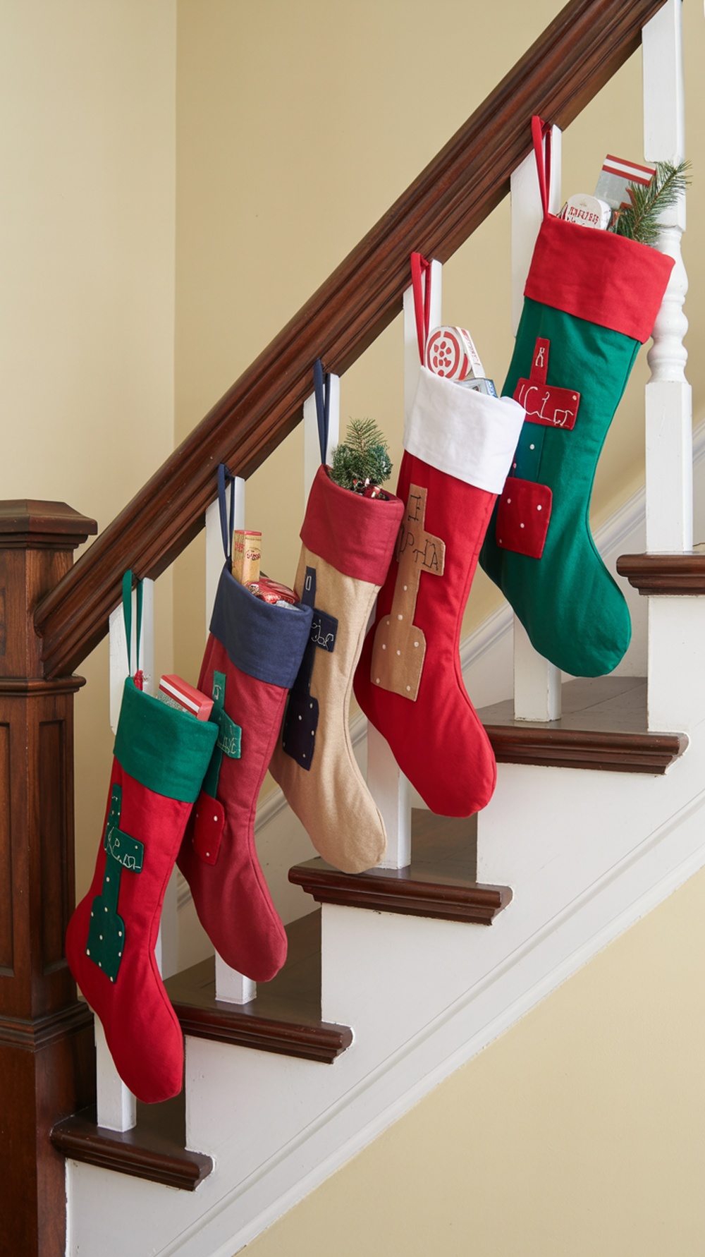 Colorful Christmas stockings hanging from a staircase railing