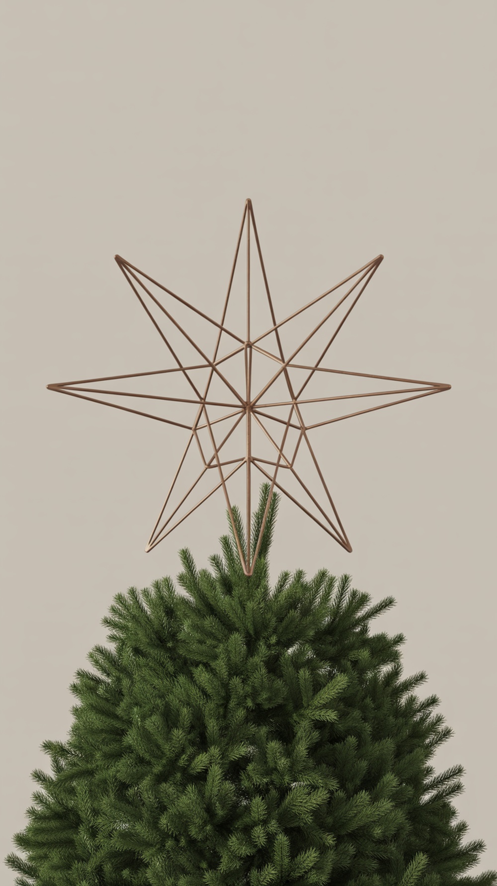 A minimalist geometric star tree topper on a Christmas tree.