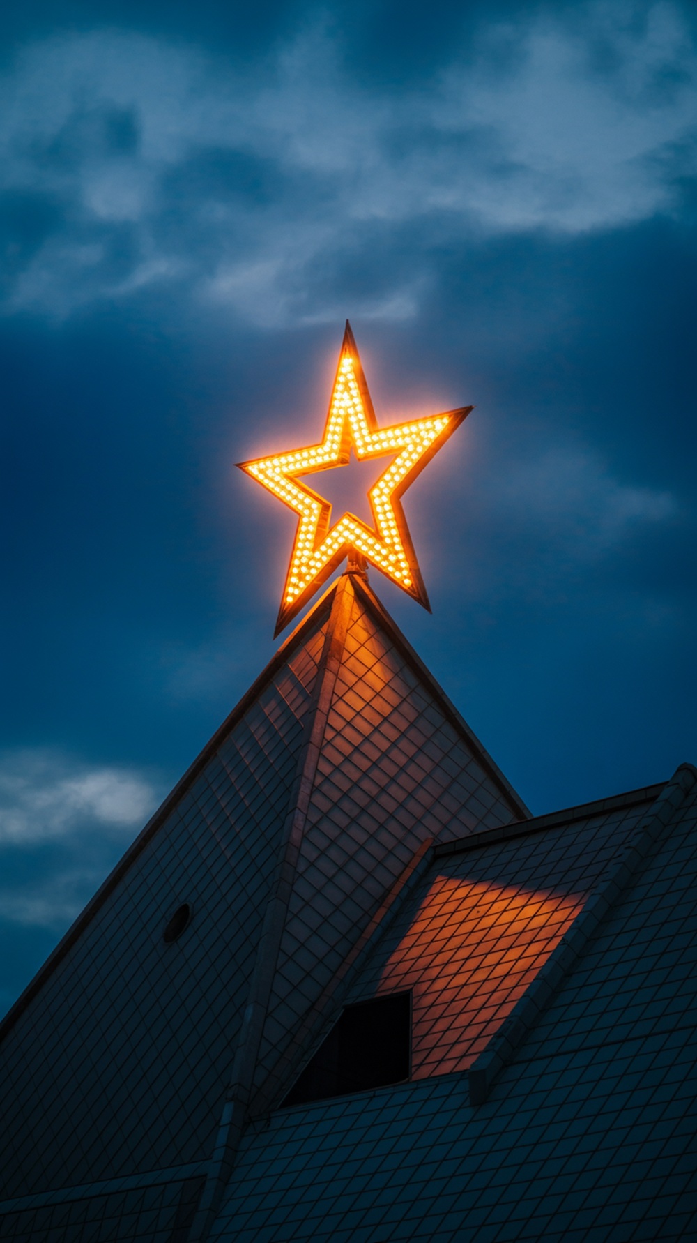 A bright star display on a rooftop against a cloudy sky
