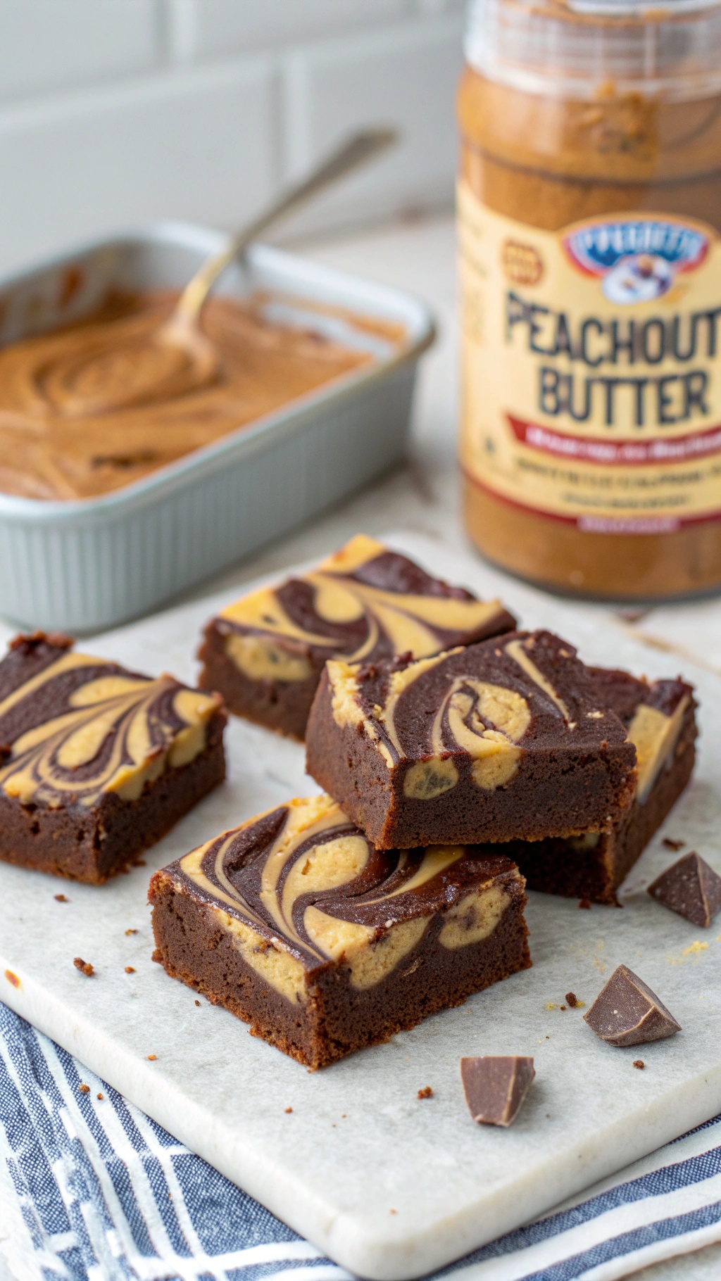 Chocolate Peanut Butter Swirl Bars cut into squares with a jar of peanut butter in the background.