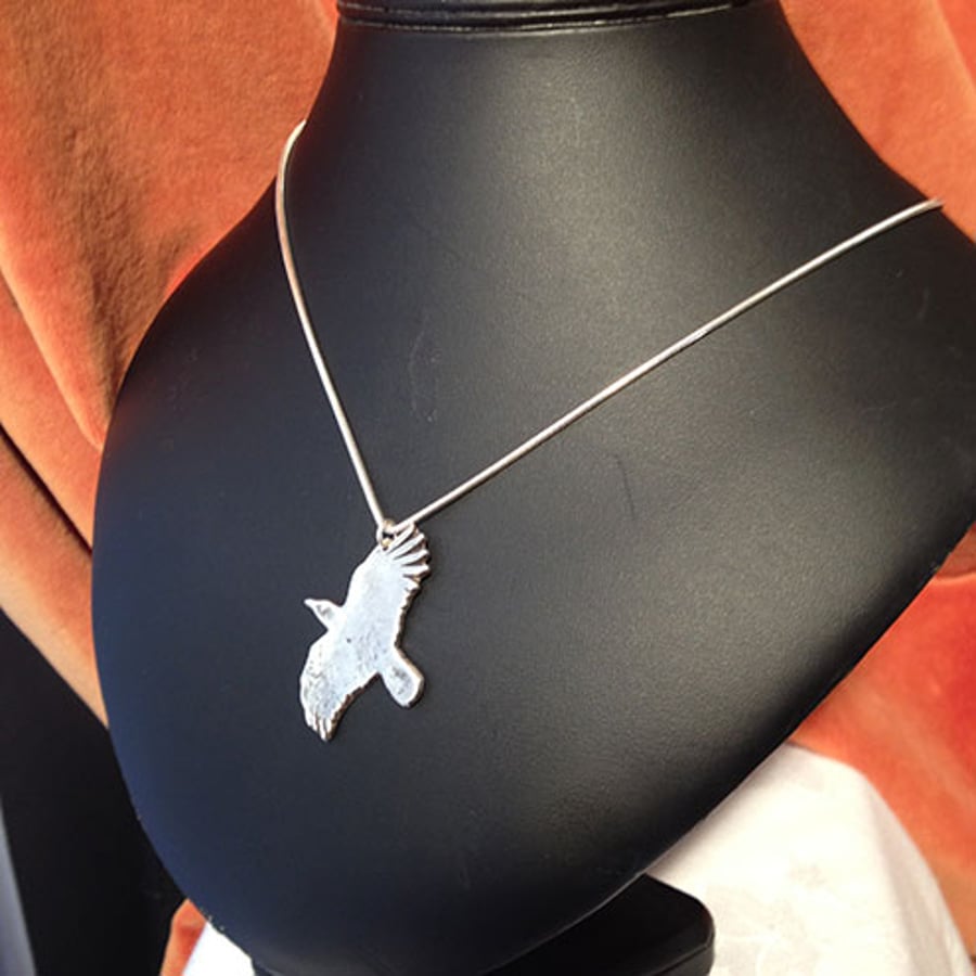 Silver crow-in-flight pendant