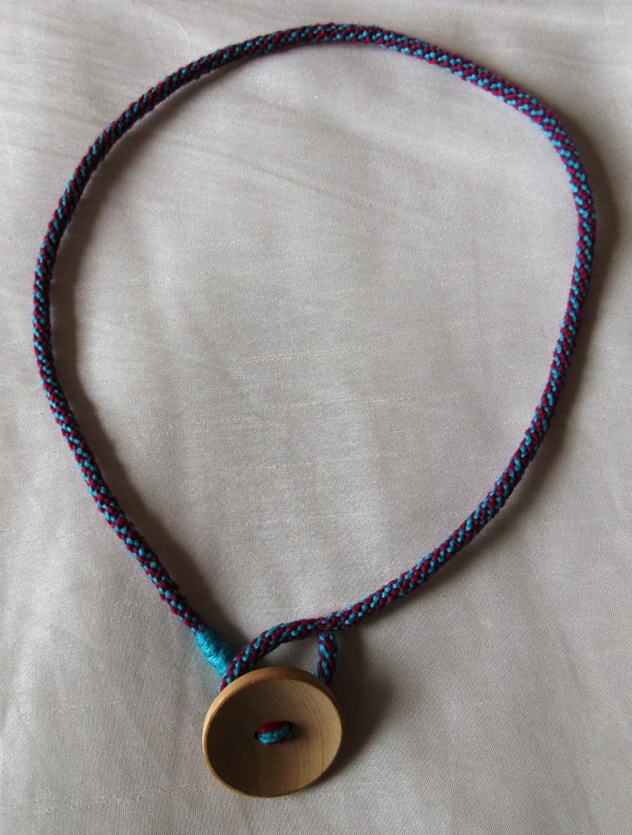A lariat-style necklace in kumihimo braid with button trim