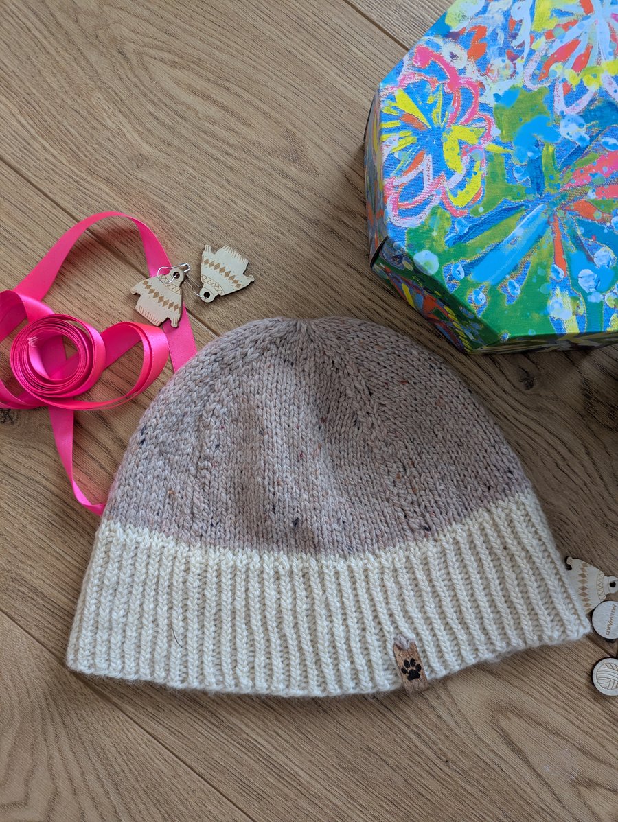 Handknit beanie hat in soft pastel pink and cream wool.