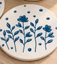 Ceramic coaster with hand drawn design. 