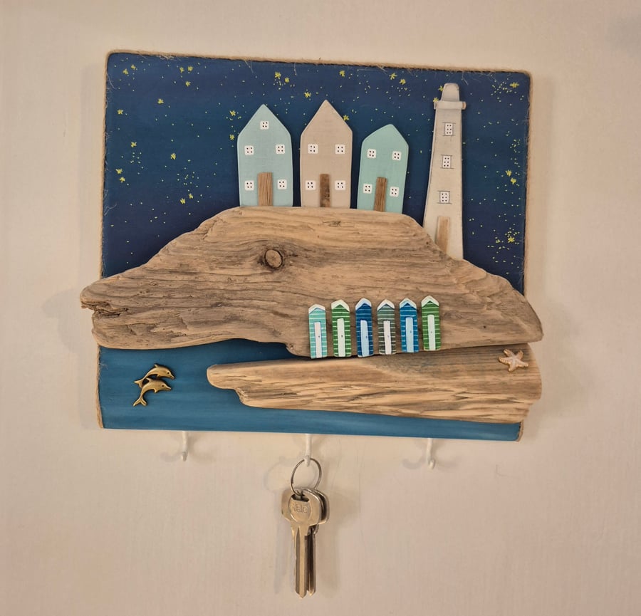 Coastal key hanger with lighthouse and cottages, stary night sky