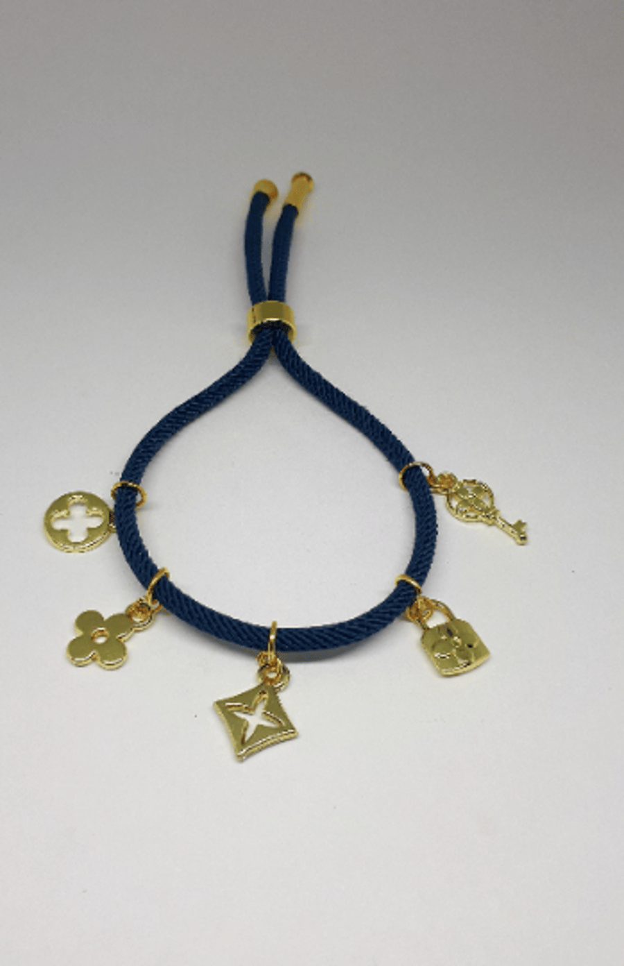 Cotton cord bracelet with gold motif charms