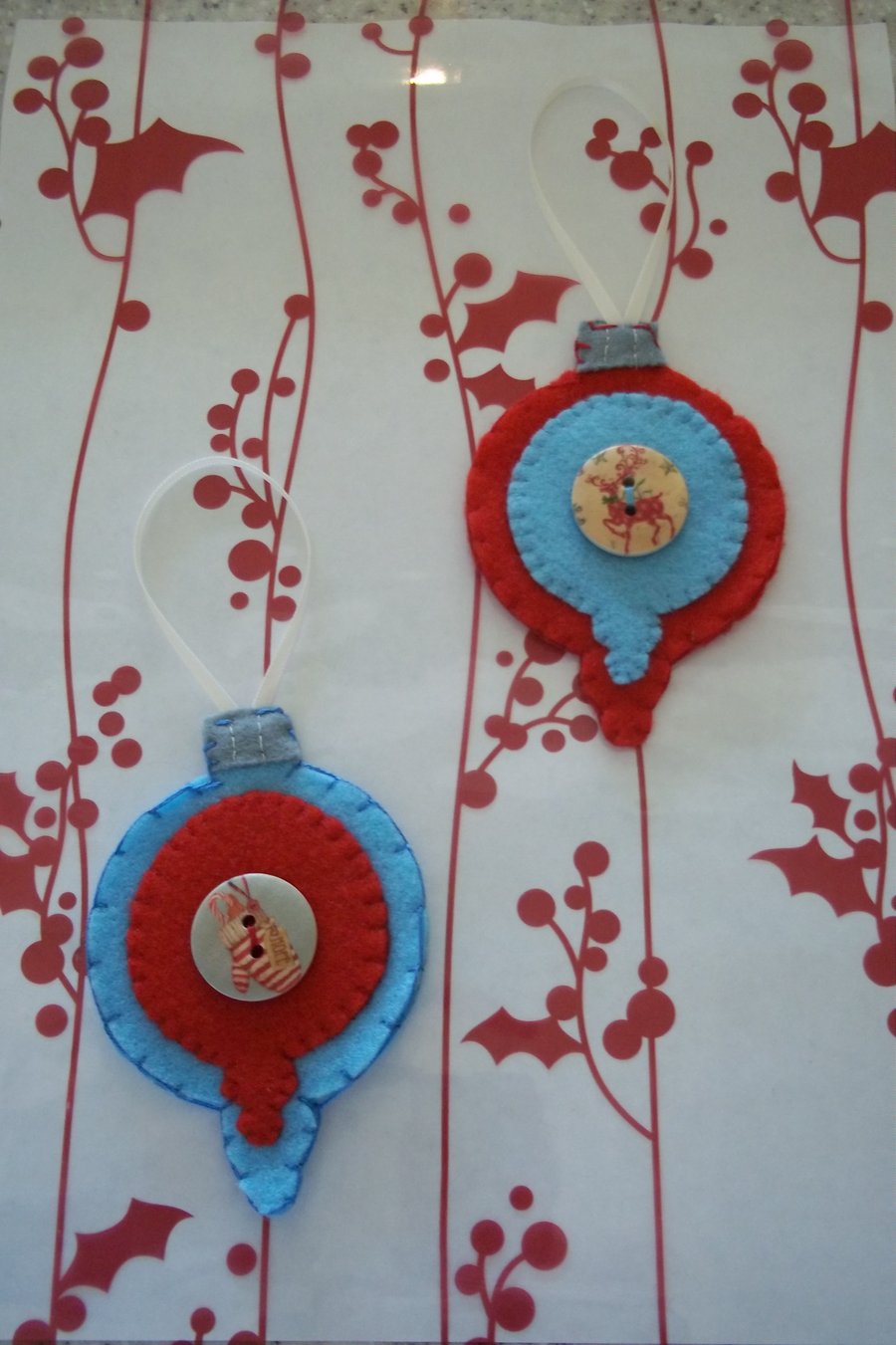 Pair of bauble shaped felt handstitched red and blue Christmas decorations