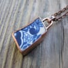 Worn pottery pendant set in aged copper bezel