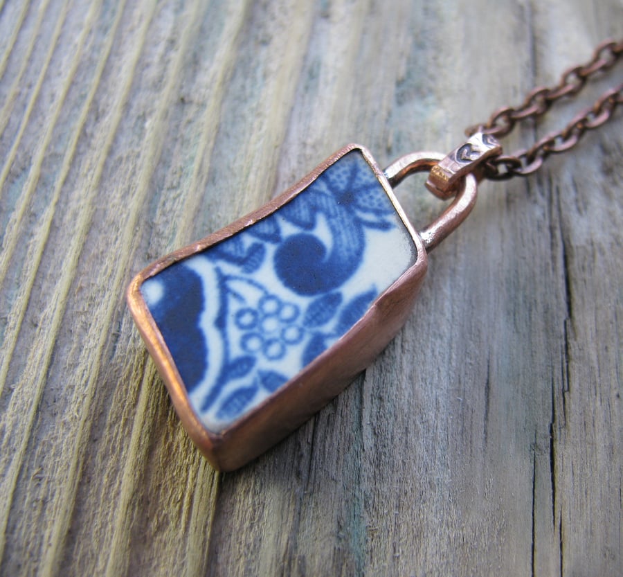 Worn pottery pendant set in aged copper bezel