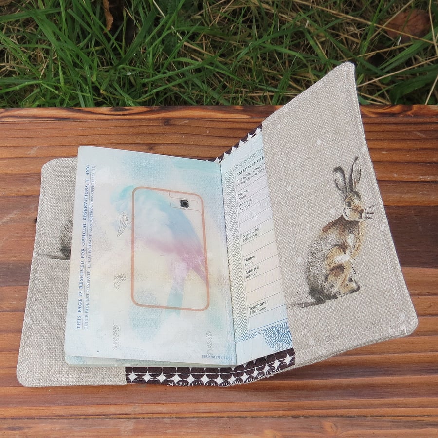 A fabric passport cover with a whimsical hare design.