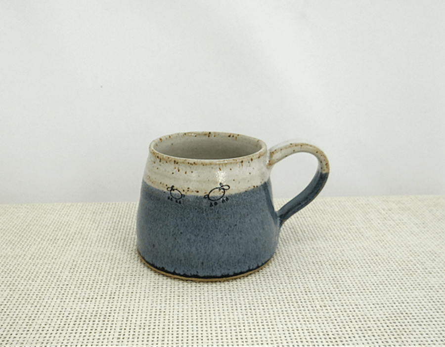 Handmade ceramic mug with lambs glazed in shades of blue and creamy white