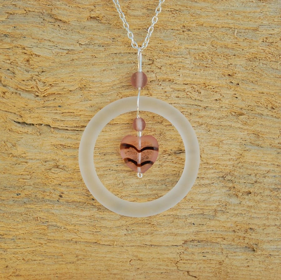 White glass ring pendant with pink heart