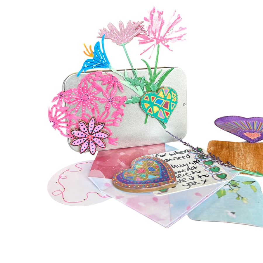 Selection of hand painted magnets, pocket hug and ephemera in a tin 