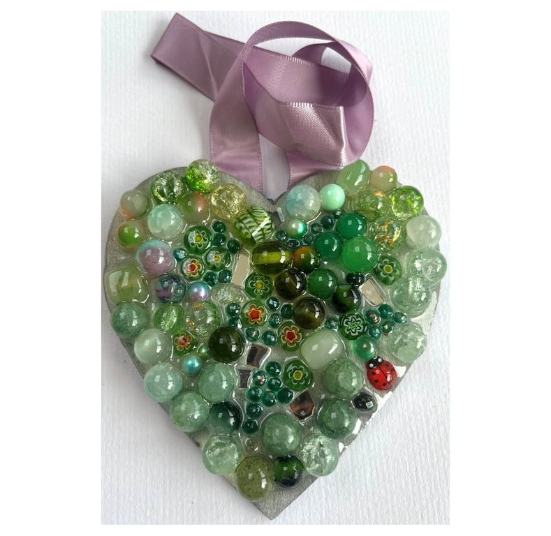A wooden heart shaped pendant with ocean green coloured spheres and decorations.