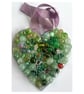 A wooden heart shaped pendant with ocean green coloured spheres and decorations.