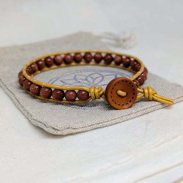 Goldstone and metallic gold leather bracelet with wooden button fastener 