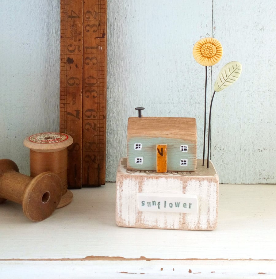Little wooden house with sunflower garden