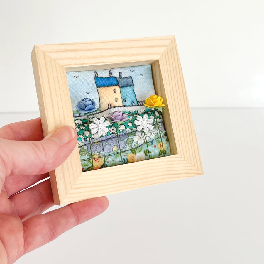 Little 3D fabric picture of houses and flowers, in a small wooden frame