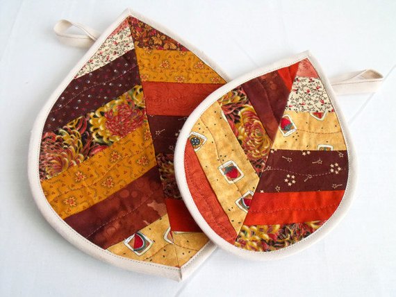 pair of leaf shaped pot holders in autumn colours,  patchwork quilted coasters