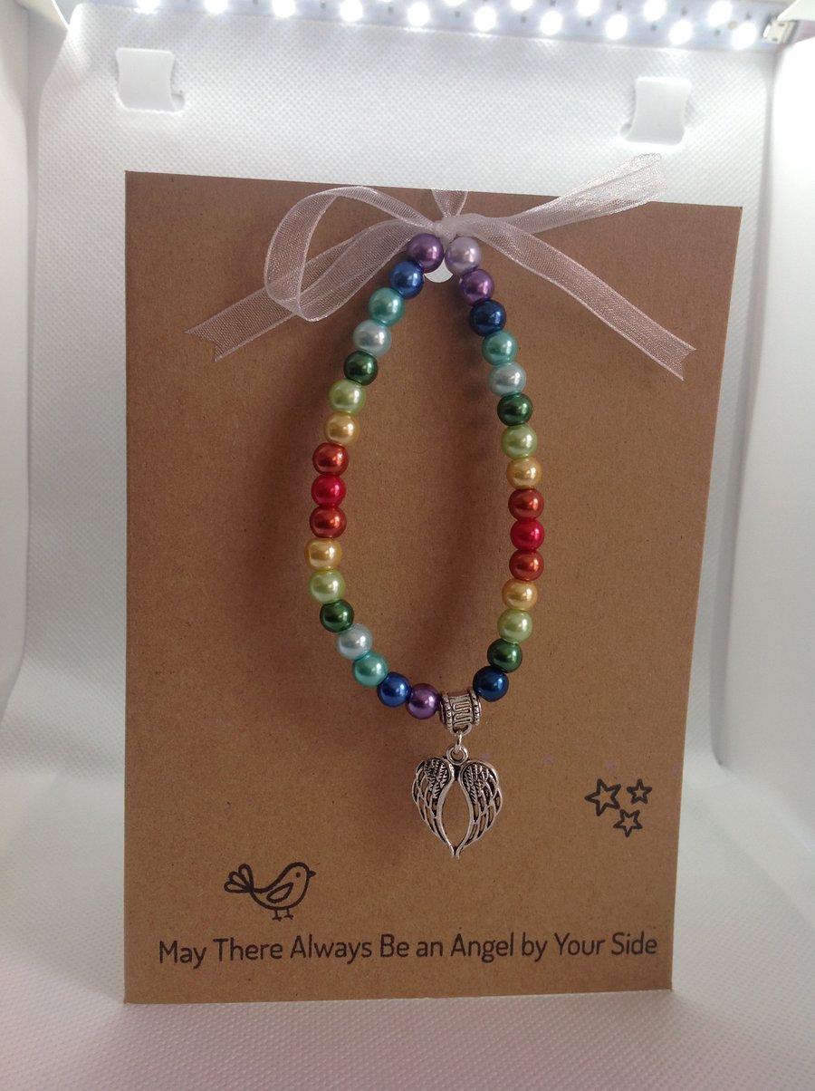 stretch bracelet in rainbow beads with angel wings charms on greetings card