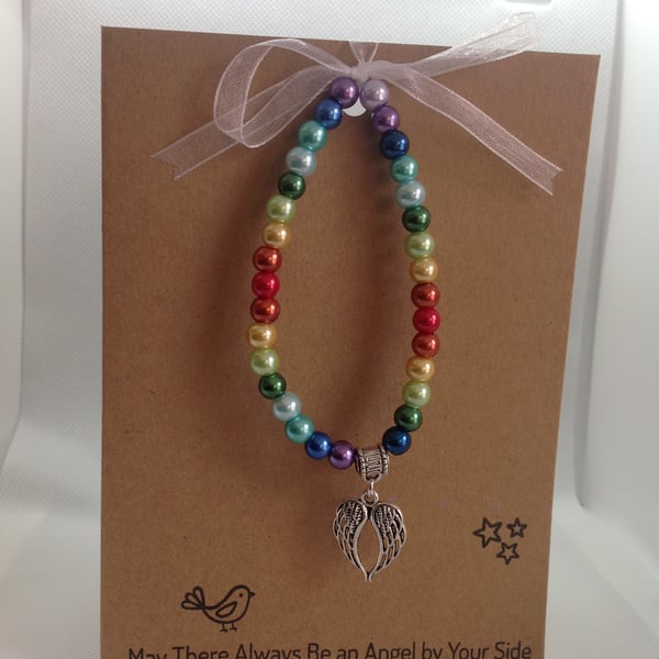 stretch bracelet in rainbow beads with angel wings charms on greetings card