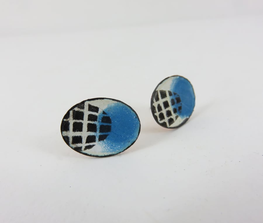 Oval enamel stud earrings with white drawn detail.