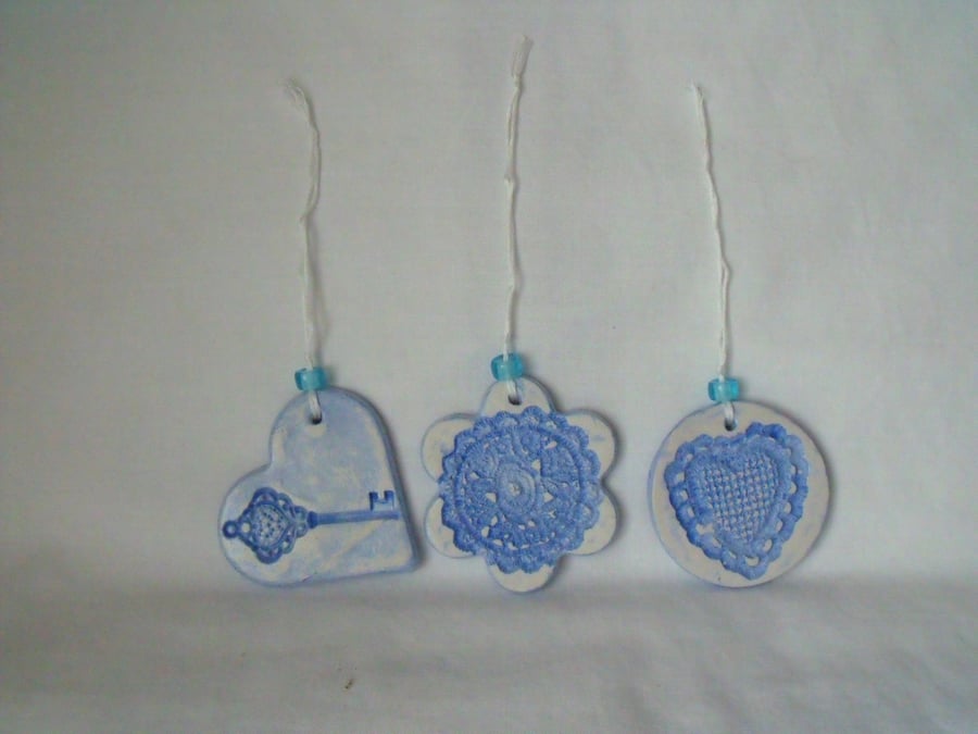 set of three impressed ceramic hanging decorations in blue