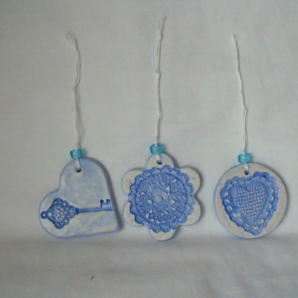 set of three impressed ceramic hanging decorations in blue