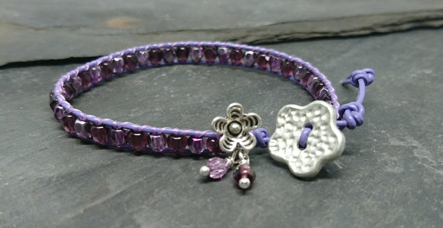 Purple leather and glass bead bracelet with flower button and flower charm