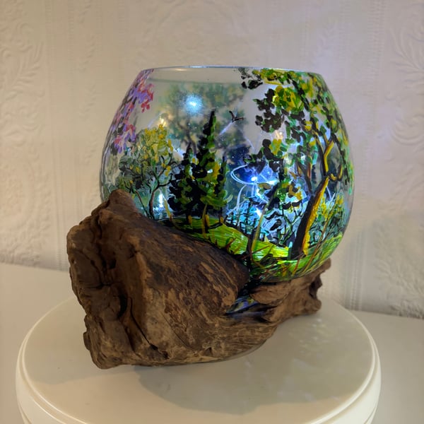 A hand painted glass bowl on driftwood by Andrew Jenkins