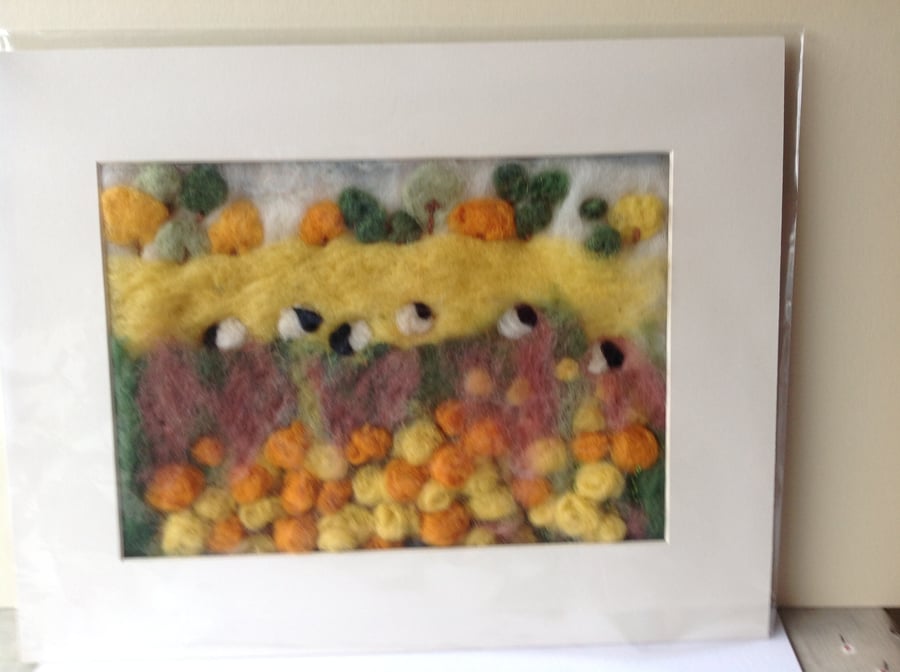 Felt picture sheep grazing in the meadow.