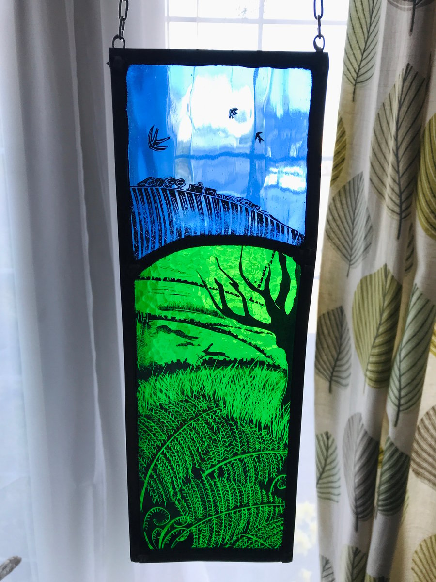 stained glass panel depicting a countryside view