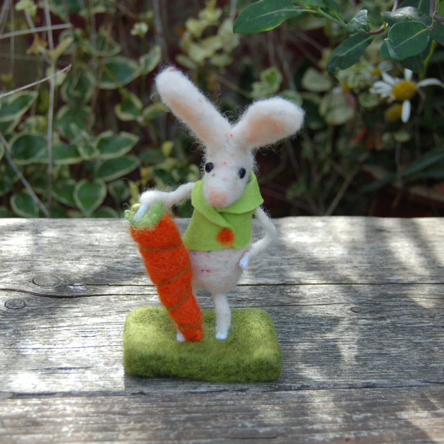 Needlefelt white rabbit wearing a jacket and holding a carrot