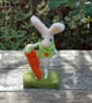 Needlefelt white rabbit wearing a jacket and holding a carrot