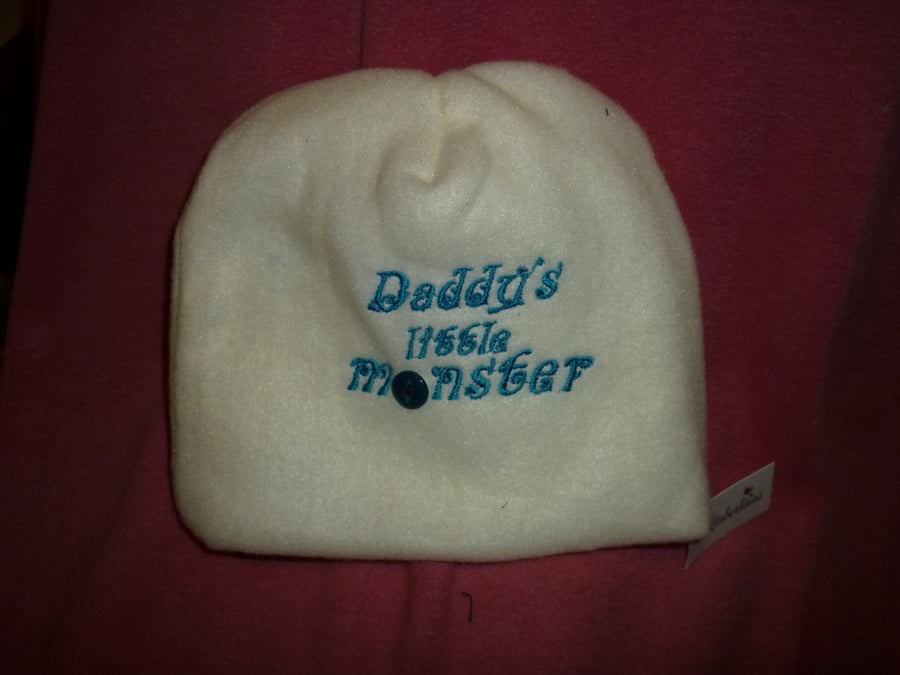 Hand made sewn baby hat in soft fleece fabric -cream with turquoise writing