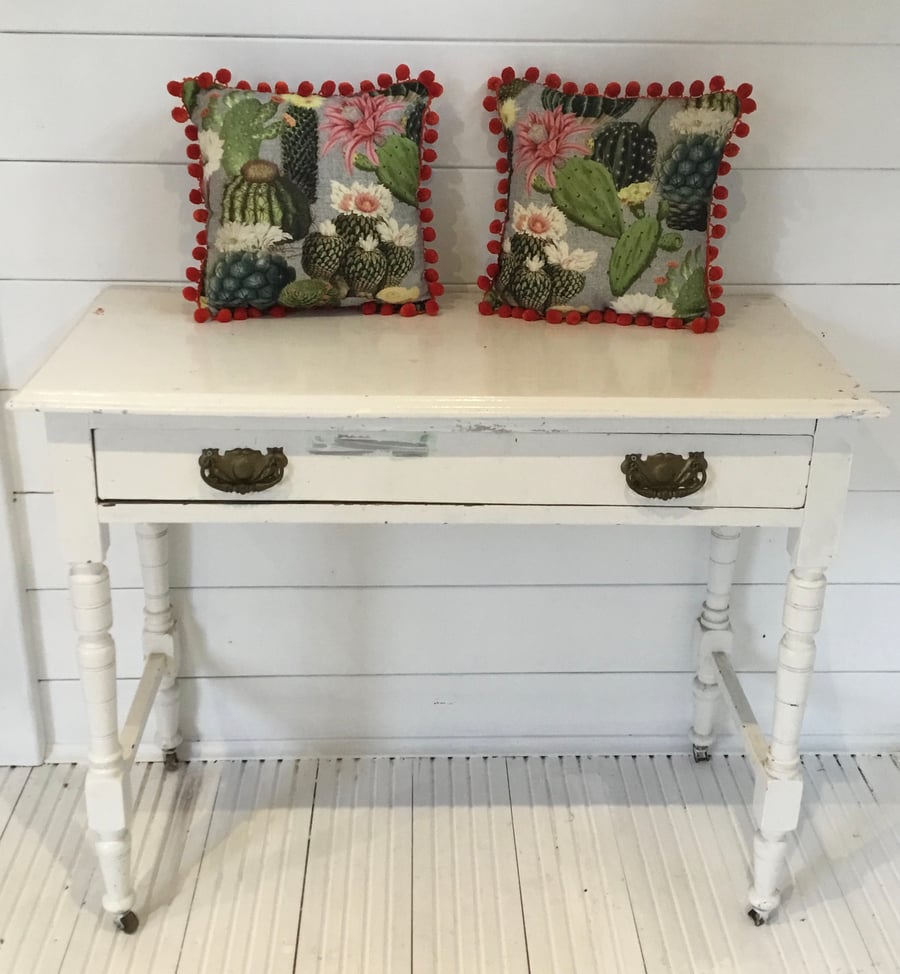 Cactus print cushions with oranges pompom trim