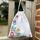 Embroidered linen drawstring bag with striped cotton back