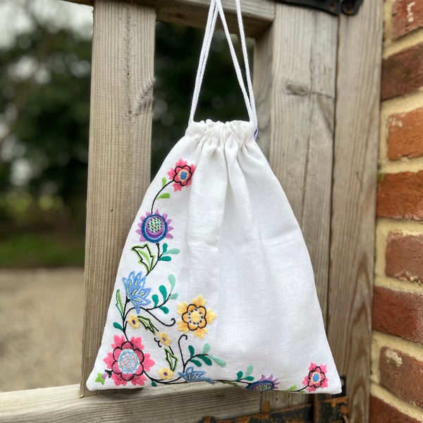 Embroidered linen drawstring bag with striped cotton back