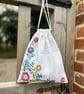Embroidered linen drawstring bag with striped cotton back