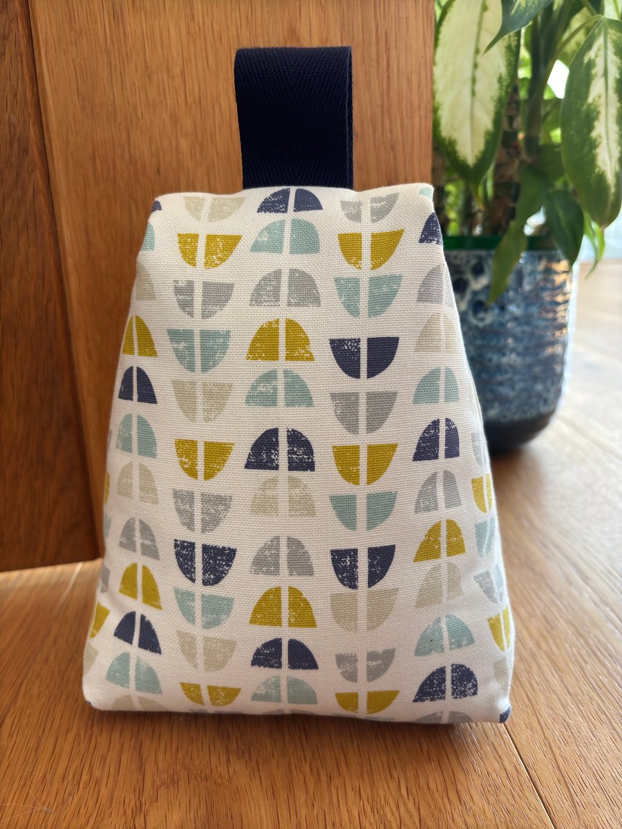 Cotton fabric doorstop in stylish geometric scandi print, filled with pebbles.