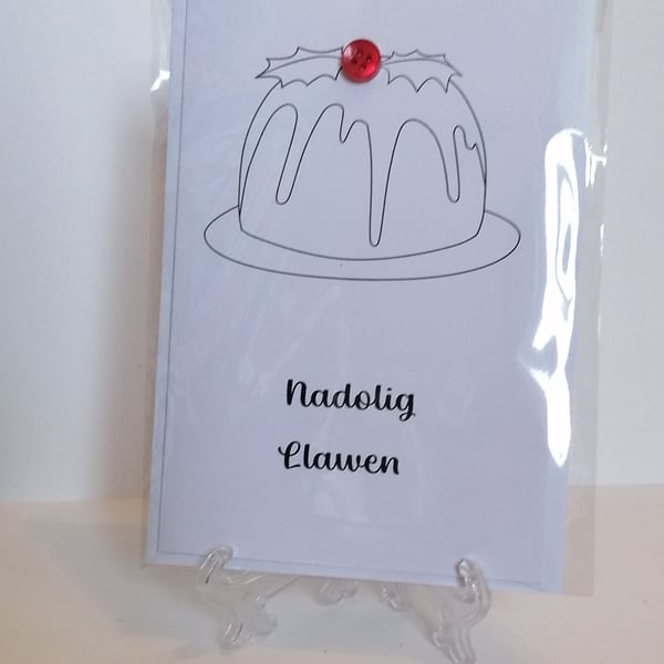 Nadolig Llawen Welsh Christmas card with a red button on a Christmas pudding