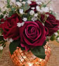 Beautiful faceted glass bowl of roses in rich red