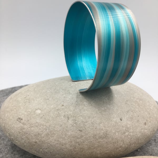 Turquoise and grey anodised aluminium striped cuff