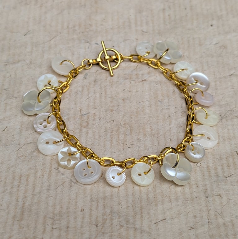 Gold coloured toggle bracelet with pearl buttons