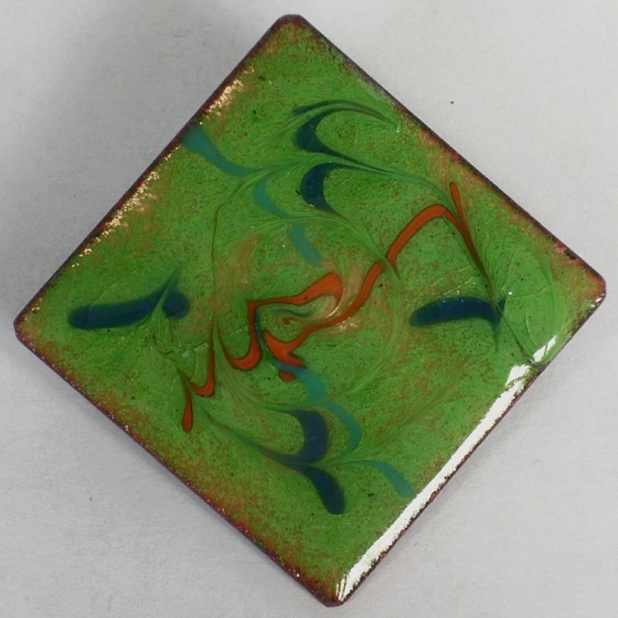 brooch - scrolled red and blue on green over clear enamel